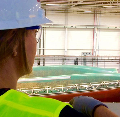 Carmen wearing PPE standing inside a fabrication warehouse.