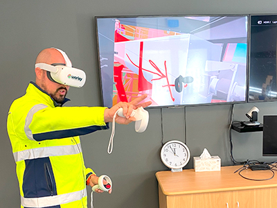 Ed wearing VR headset with controllers in hands.