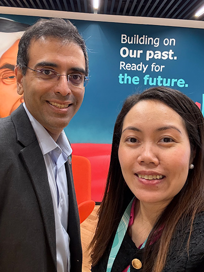 Enrica with a work colleague in front of a Worley banner at a conference.