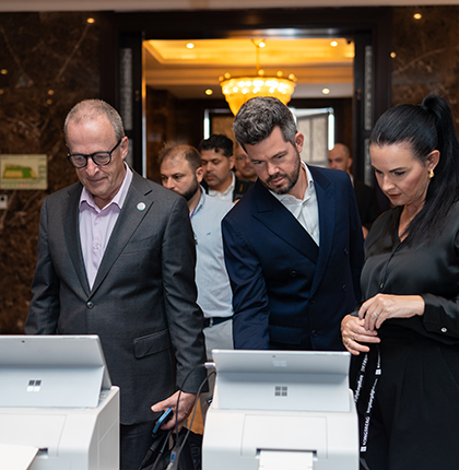 John with other colleagues standing in front of and looking at laptop screens.