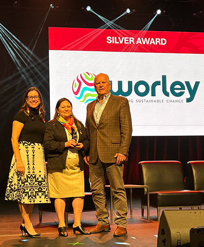 Linette with two of her team standing on stage after Worley winning a Silver award.