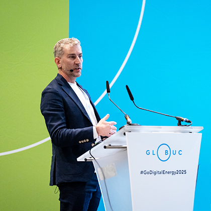 Paul standing at a lectern speaking into a microphone at the Go Digital Energy 2025 event.