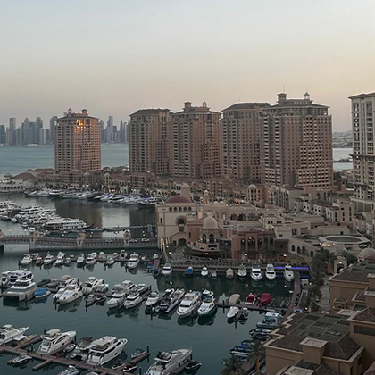 The Pearl-Qatar marina with yachts, waterfront buildings, and the Doha skyline in the background