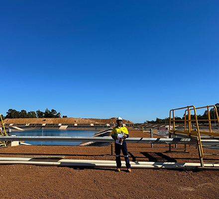 Sunil standing near a water dam in PPE suit