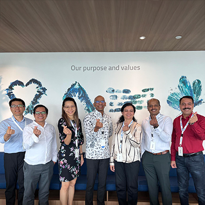 Weerapa standing in a line with 6 other people clicking their fingers.