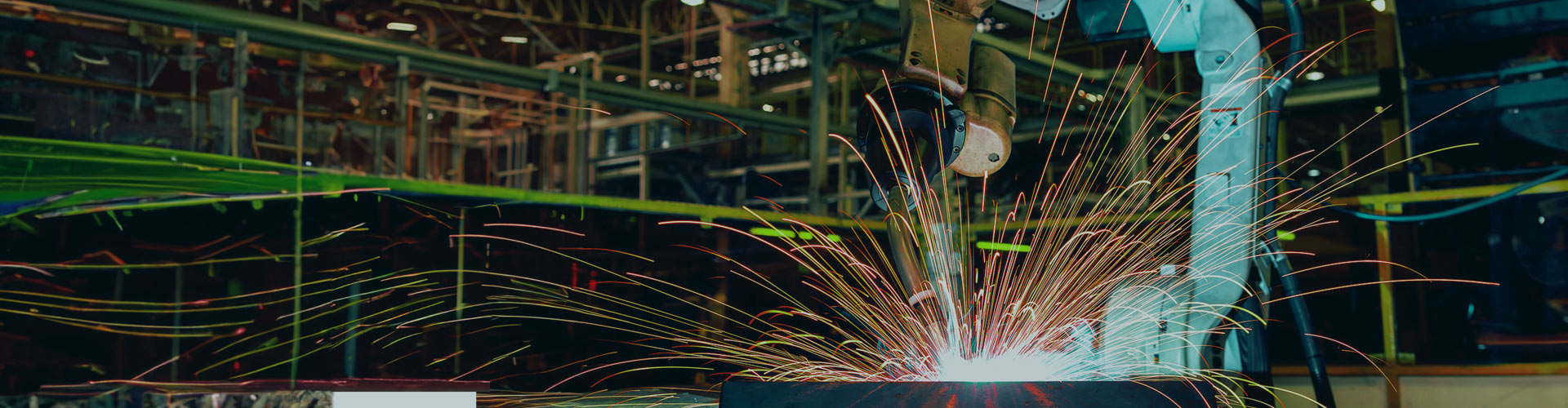 Modern industrial setting with a working robotic arm creating sparks.