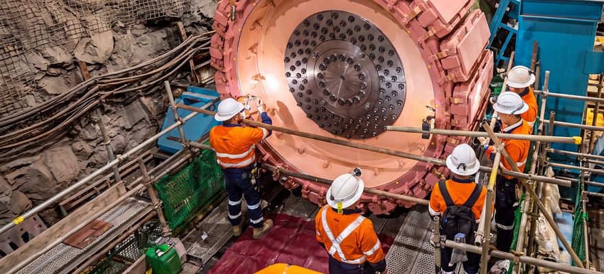 People wearing PPE working on mining machinery.