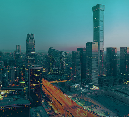Close view of a modern city skyline with illuminated office towers at dusk.