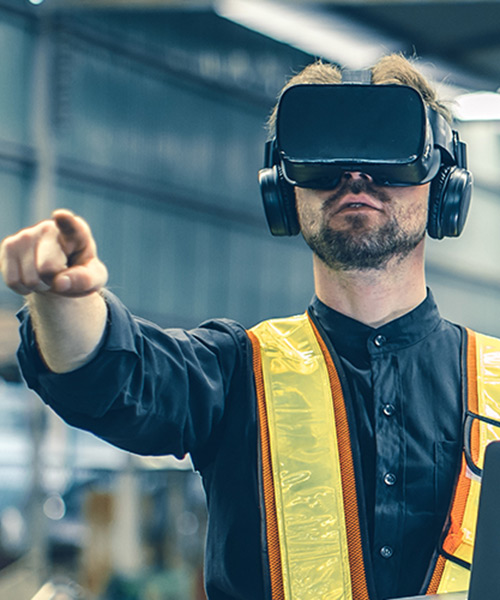 Person wearing a virtual reality headset with their arm outstretched pointing.