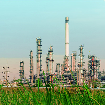 Refinery infrastructure showing processing towers and pipelines at an industrial energy facility.