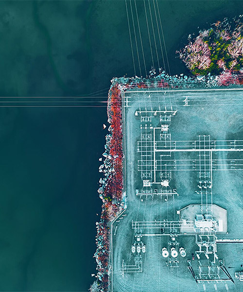 Aerial view of a power plant next to a body of water.