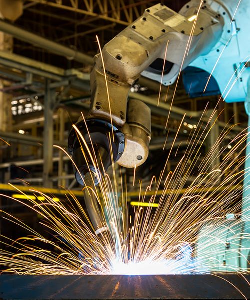 Modern industrial setting with a working robotic arm creating sparks.
