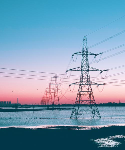 Row of transmission lines and a pink sky.