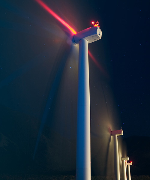 Single wind turbine against the black sky.