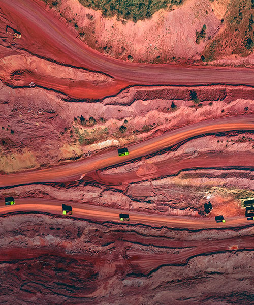 Aerial view of a mine with haul trucks driving along the road.