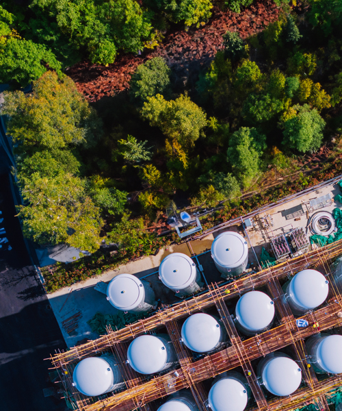 Aerial view of rows of tanks at a plant.