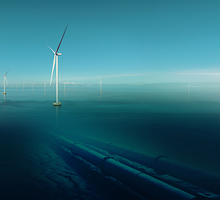 Offshore wind turbines above calm water with a subsea pipeline below.