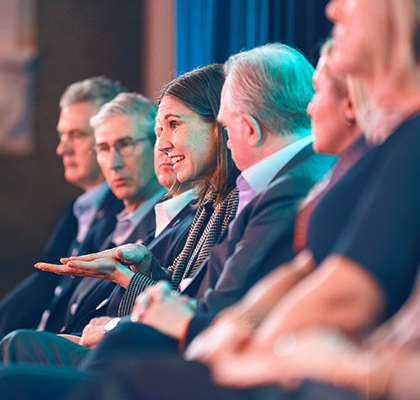 Group of Worley's Group Executive sitting in a row on stage.