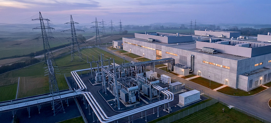 Aerial view of a large data center situated next to rows of power lines.