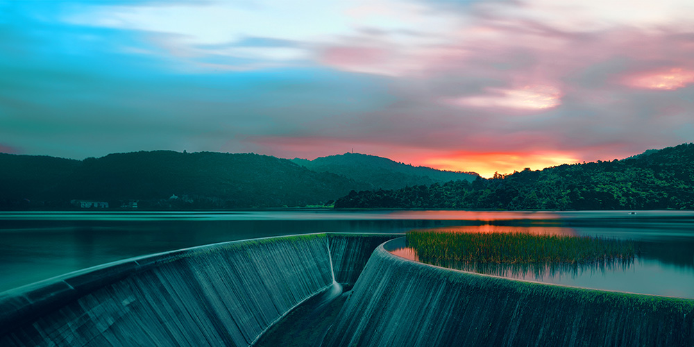 Hydropower plant with golden sun setting.