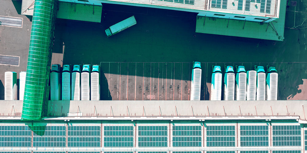 Aerial view of a building with heavy vehicle trucks lined in a row.