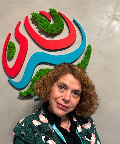 Cecilia standing in front of Worley logo on the wall.