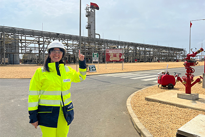 Claudia dressed in PPE standing outside a large steel structure.
