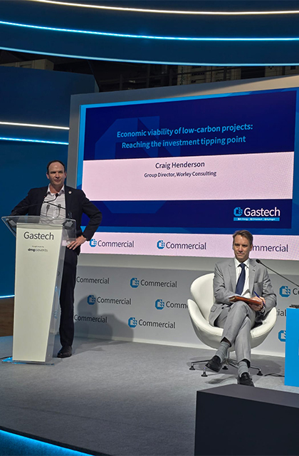 Craig standing on stage presenting at the Gastech conference.
