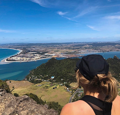 Harriet standing on a mountain looking out over the landscape towards the water.