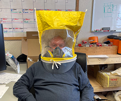Martin wearing a powered air‑purifying respirator hood for respiratory safety.