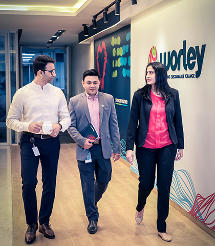 Three people walking together talking down a hallway in Worley office.