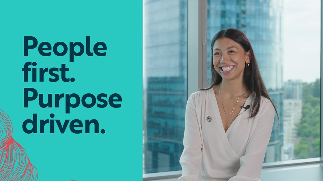 Smiling Worley woman sitting in front of the window. Text overlay: People first. Purpose driven.