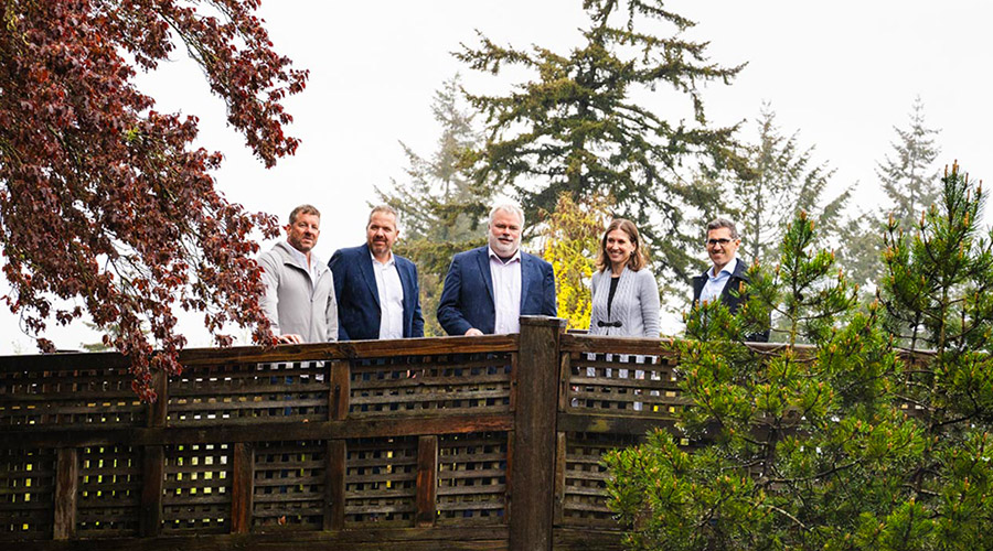 Group of five people from Worley and Nano One standing on a bridge amongst trees.