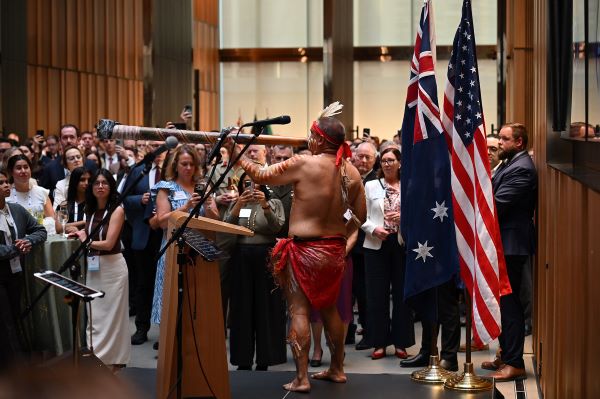Indigenous dancer on stage in front of a crowd performing.