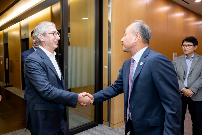 Mark Trueman and Hong Namkoong shaking hands.