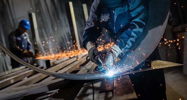 Man welding metal in a workshop.