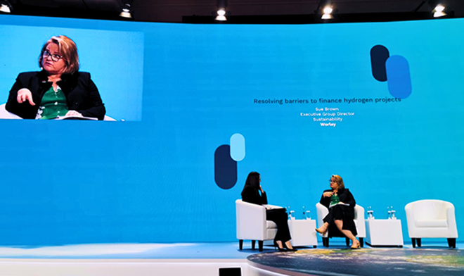 Sue Brown of Worley sitting on stage at COP28 being interviewed.