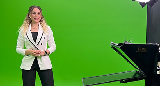 Jamila, project engineer with Worley, standing in front of a green screen with filming equipment.