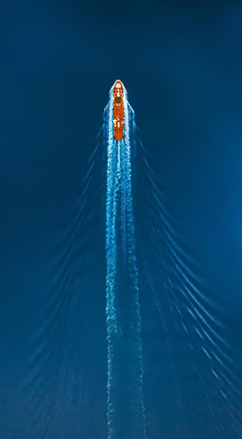 Aerial view of a tanker gliding through the ocean.