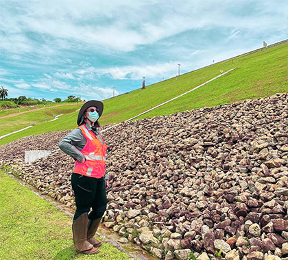 Person wearing a face mask standing outside next to rocks.