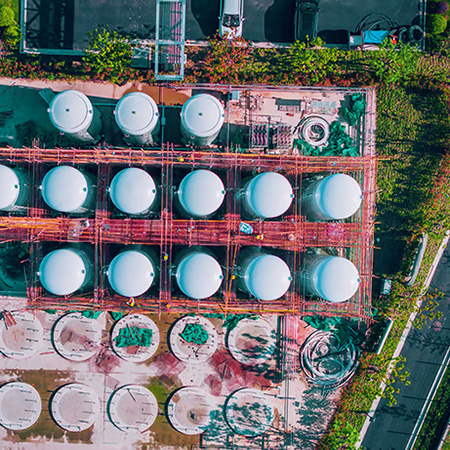 Aerial view of rows of tanks at a plant.